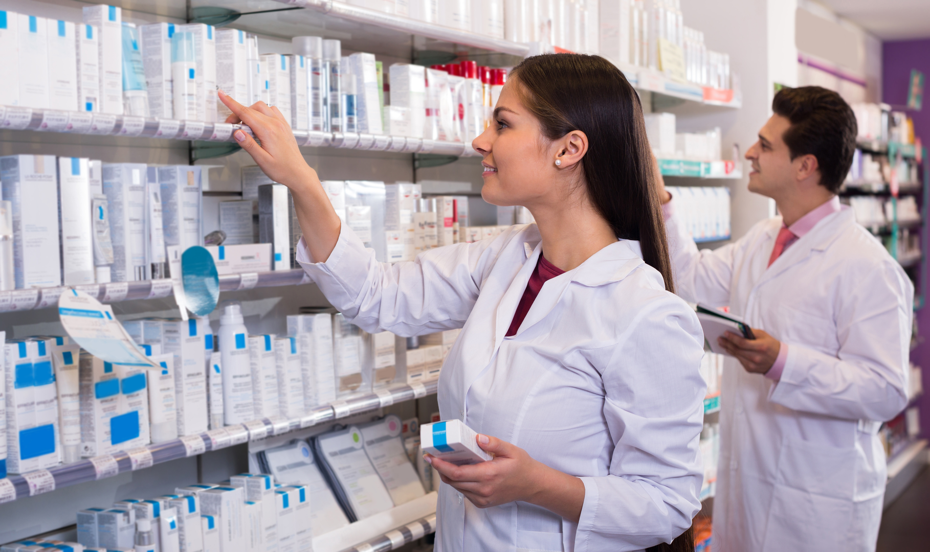 Two pharmacists filling prescriptions in a pharmacy