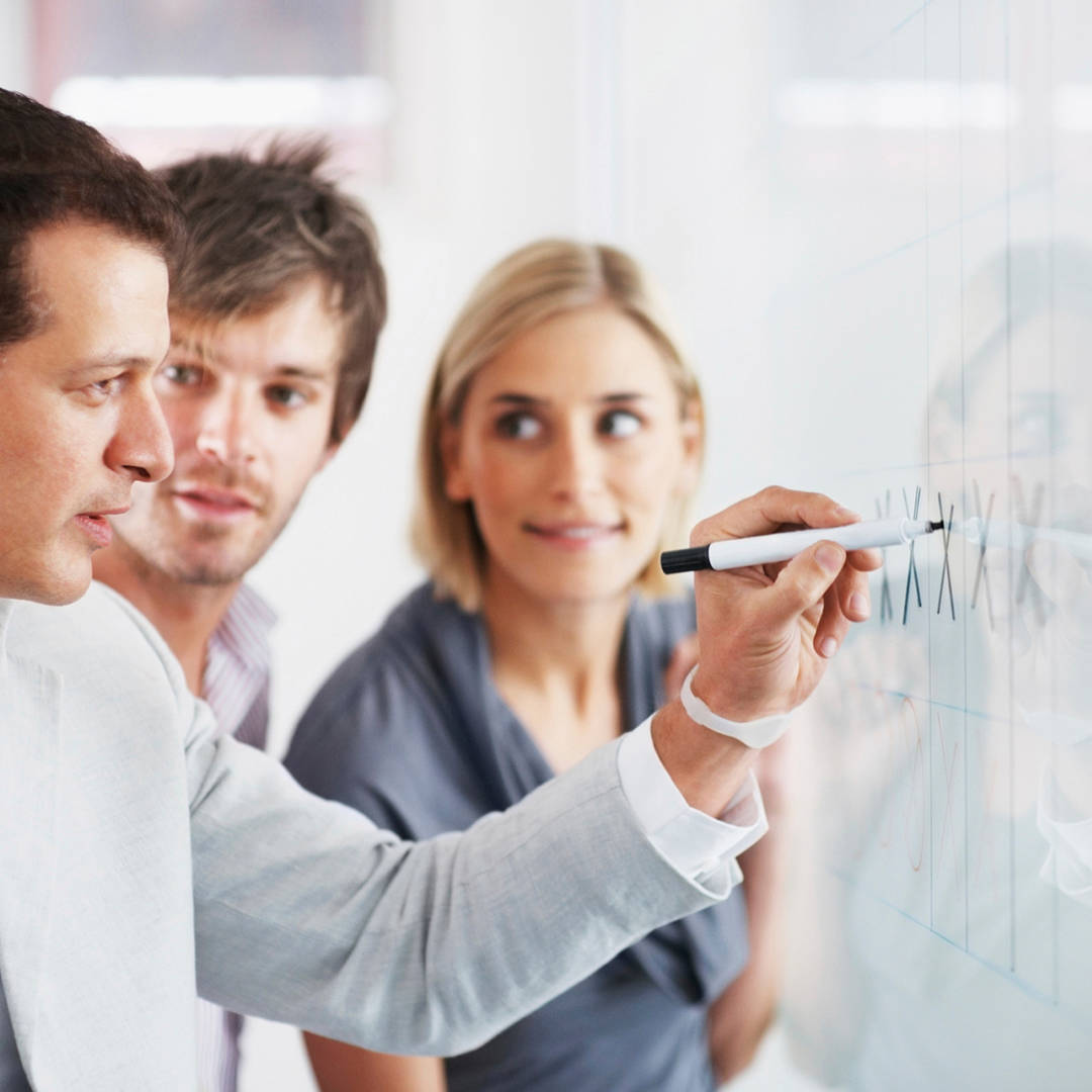 Group meeting with man writing on a white board