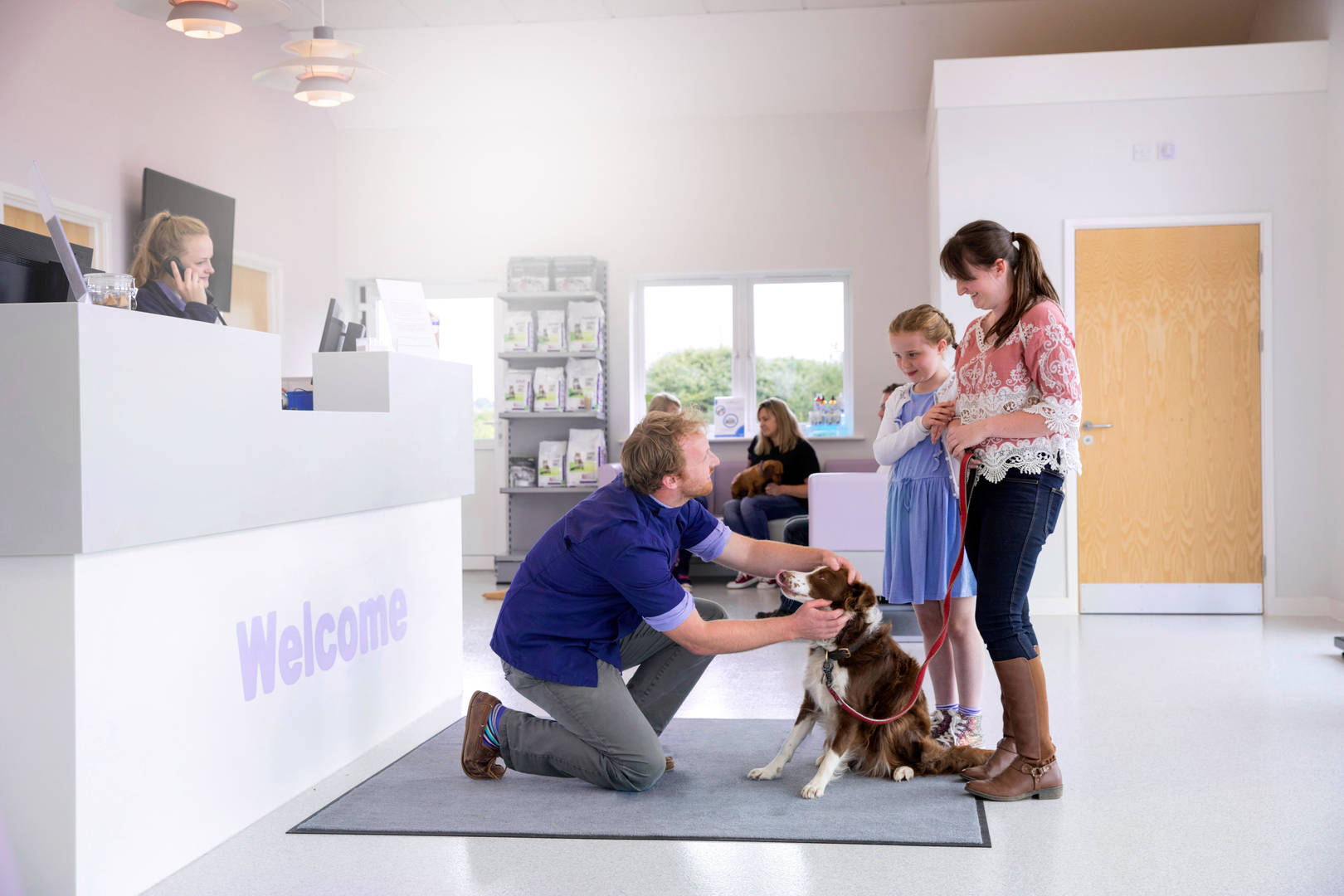 Pet owners greeted at front desk of veterinary practice