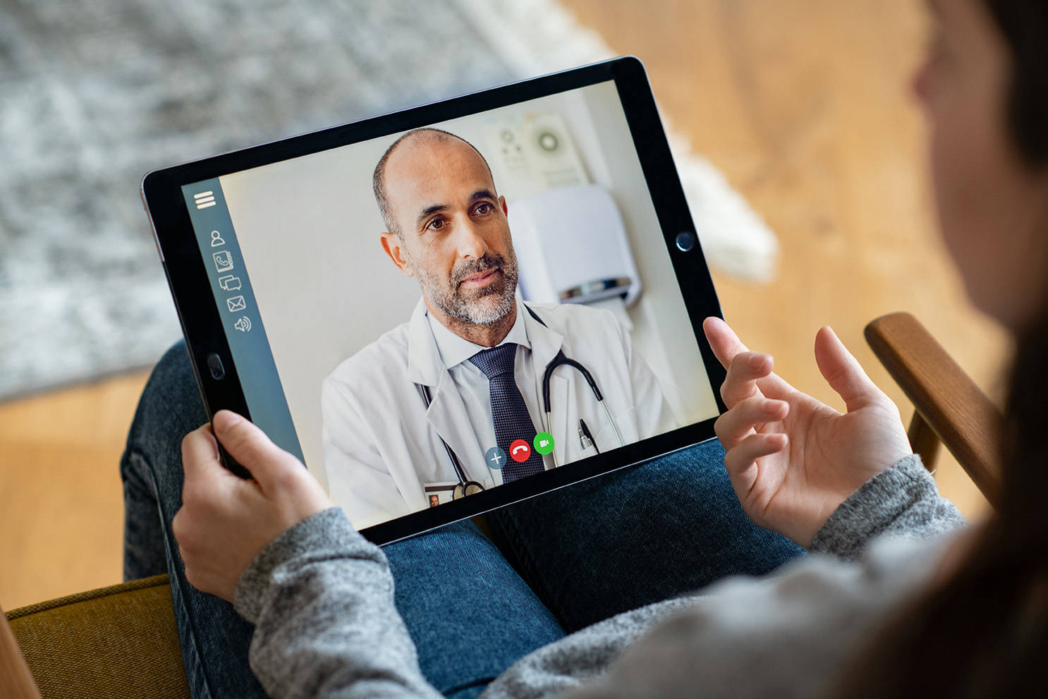Male doctor speaking to patient on a tablet